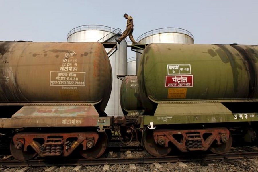 A worker walks atop a tanker wagon to check the freight level at an oil terminal on the outskirts of Kolkata, India, in this November 27, 2013 file photo — Reuters