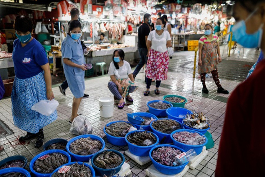 Vendors and customers wear masks for protection against the coronavirus disease (Covid-19) while making transactions at a market in Quezon City, Metro Manila, Philippines, July 21, 2020. REUTERS