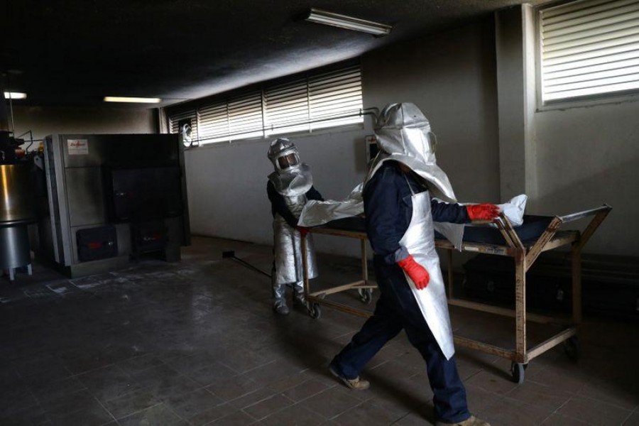 Crematory workers are pictured next to a body bag containing the corpse of Lorenzo who died of the coronavirus disease (Covid-19) at a crematory in Mexico City in Mexico on August 2, 2020 — Reuters photo