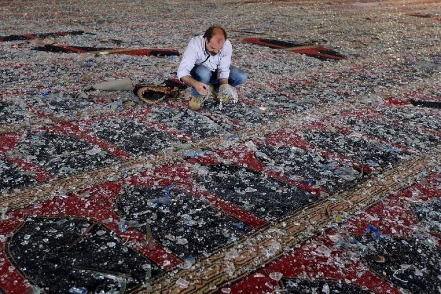 A man removes broken glass scattered on the carpet of a mosque damaged in Tuesday's blast in Beirut, Lebanon, August 05, 2020 — Reuters
