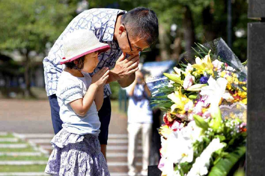 A man and his daughter pray for the victims of US atomic bombing at the Atomic Bomb Hypocenter Park in Nagasaki, southern Japan. AP Photo