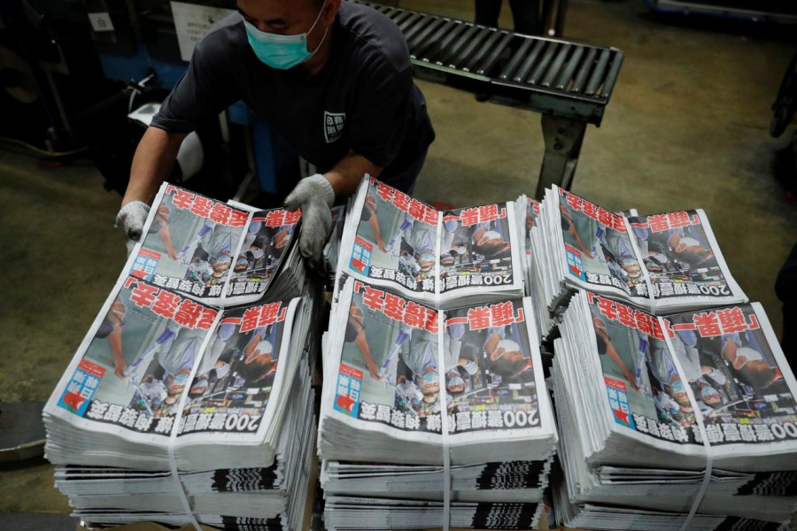 Bundles of the Apple Daily newspaper, published by Next Media Ltd, with a headline "Apple Daily will fight on" after media mogul Jimmy Lai Chee-ying, founder of Apple Daily was arrested by the national security unit, are seen at the company's printing facility in Hong Kong, China August 11, 2020. REUTERS/Tyrone Siu