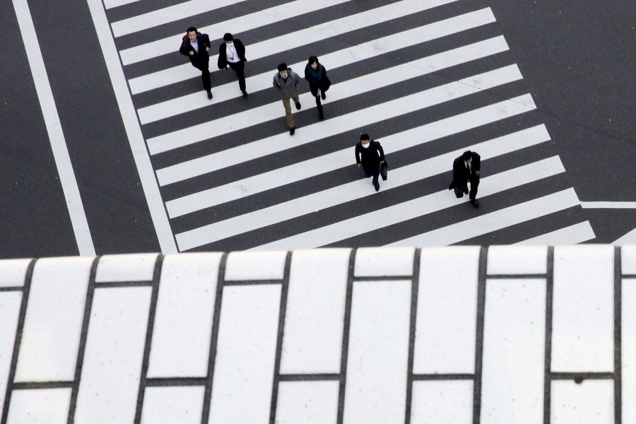 People cross a street in a business district in Tokyo, Japan, February 16, 2016 — Reuters/Files
