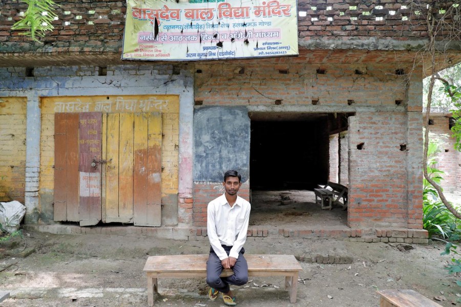 Ashish Kumar, 20, who used to work at a plastics factory in western India, poses outside a primary school where he studied in Dutta Nagar village in Gonda district in the northern state of Uttar Pradesh, India, July 10, 2020. REUTERS/Pawan Kumar