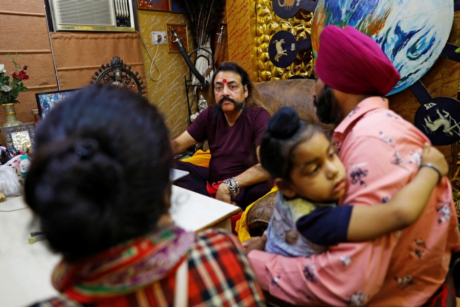 Sanjay Sharma, a mystic healer and astrologer, talks to a family, who came to him with their problem, as he sits in his office, amidst the spread of the coronavirus disease (Covid-19), in New Delhi, India, August 22, 2020 — Reuters