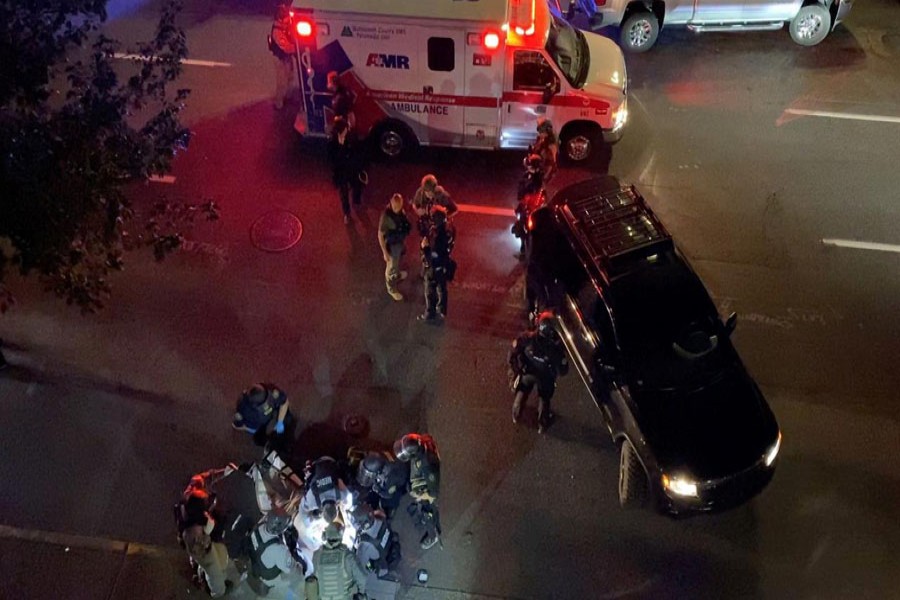 Medics and police personnel (bottom) surround the victim of a shooting in Portland, Oregon, U.S. August 29, 2020, in this still image obtained from a social media video. Courtesy of Sergio Olmos/Social Media via REUTERS.