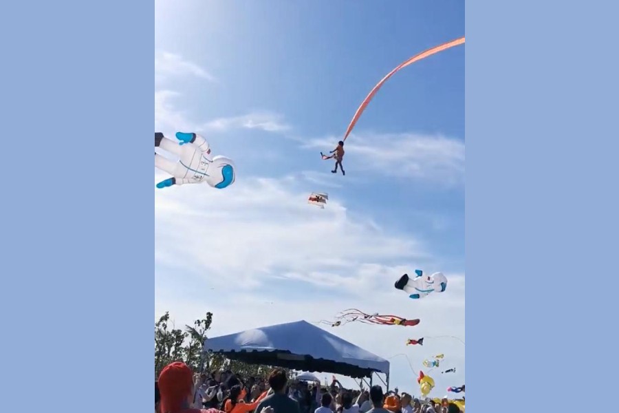 A child is pulled up in the air by a kite at an International Kite Flying Festival, in Hsinchu, Taiwan August 30, 2020 in this screen grab obtained from a social media video. Facebook @viasblog.tw/via REUTERS