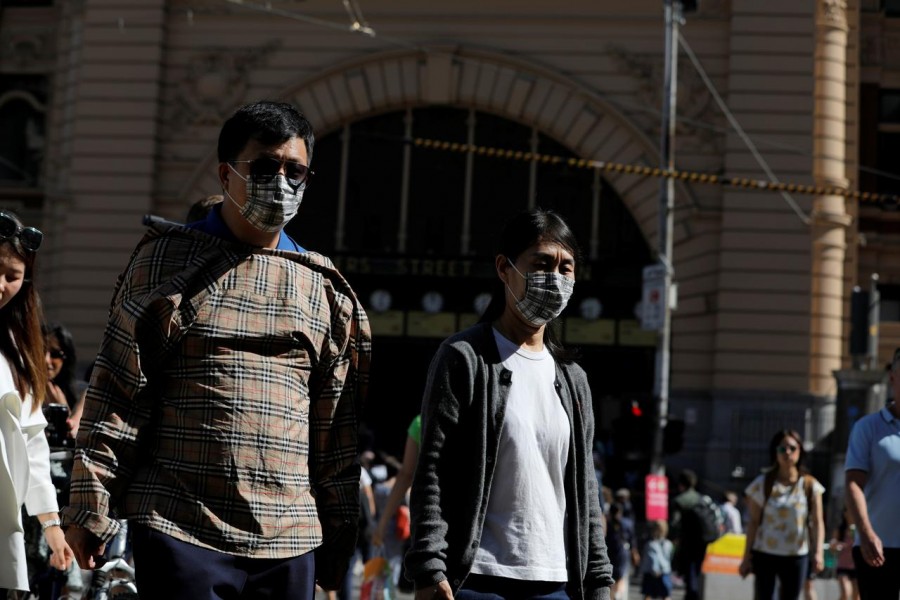 People wearing face masks walk by Flinders Street Station after cases of the coronavirus were confirmed in Melbourne, Victoria, Australia, January 29, 2020. REUTERS/Andrew Kelly