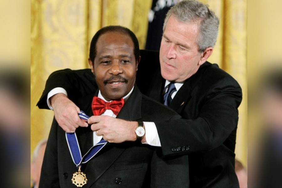 US President George W Bush (R) presents his Presidential Medal of Freedom to Paul Rusesabagina, who sheltered people at a hotel he managed during the 1994 Rwandan genocide, at a ceremony in the East Room of the White House in Washington November 9, 2005. REUTERS