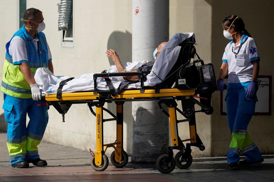 FILE PHOTO: Healthcare workers wearing protective masks push a patient on a stretcher near the emergency unit at 12 de Octubre hospital, amid the outbreak of the coronavirus disease (COVID-19), in Madrid, Spain August 14, 2020. REUTERS/Juan Medina