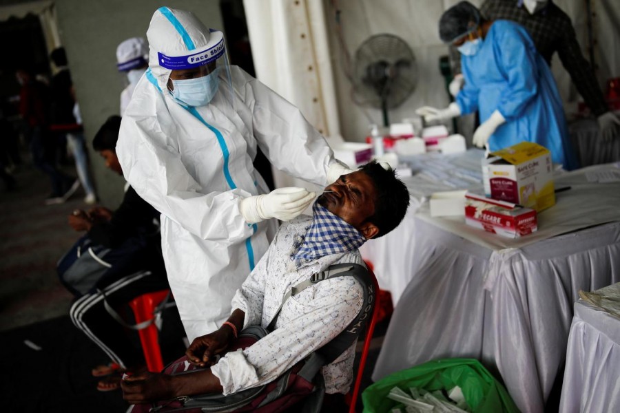 A healthcare worker wearing personal protective equipment (PPE) takes a swab from a migrant worker, who returned to Delhi from his native state, for a rapid antigen test at a bus terminal, amidst the coronavirus disease (COVID-19) outbreak in New Delhi, India on August 17, 2020 — Reuters/Files