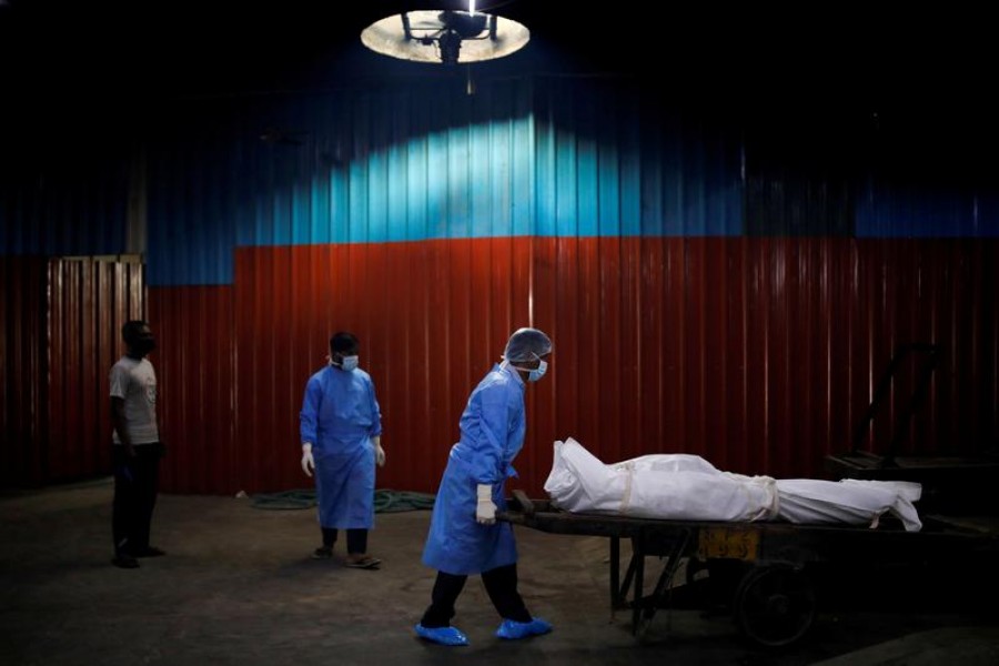 A health worker wearing personal protective equipment (PPE) carries the body of a man, who died due to the coronavirus disease (Covid-19), at a crematorium in New Delhi, India on September 7, 2020 — Reuters photo