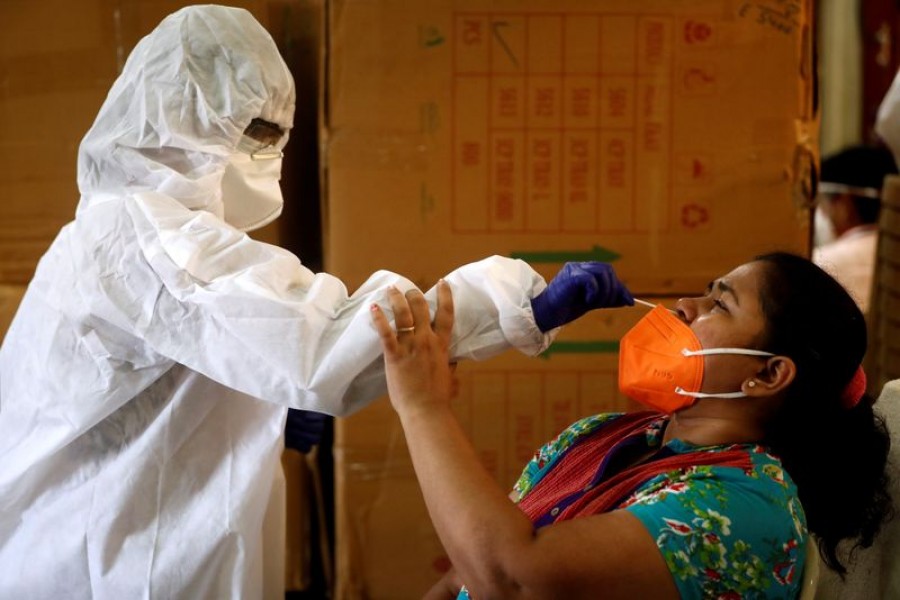 A health worker in personal protective equipment (PPE) collects a swab sample from a woman during a rapid antigen testing campaign for the coronavirus disease (COVID-19) in Mumbai, India on September 7, 2020 — Reuters photo