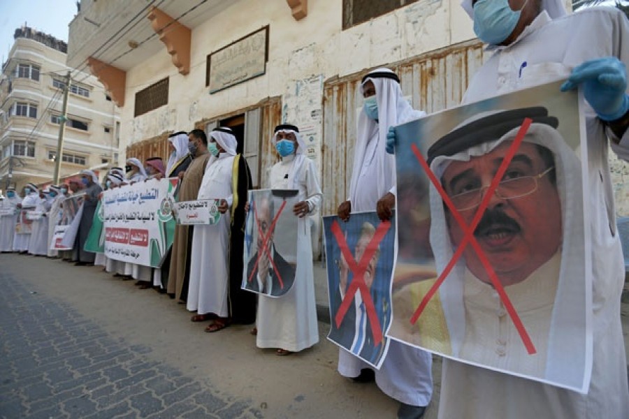 Palestinians hold crossed out posters depicting Bahrain's King Hamad bin Isa Al Khalifa, US President Donald Trump and Israeli Prime Minister Benjamin Netanyahu during a protest against Bahrain's move to normalise relations with Israel, in the central Gaza Strip September 12, 2020 — Reuters