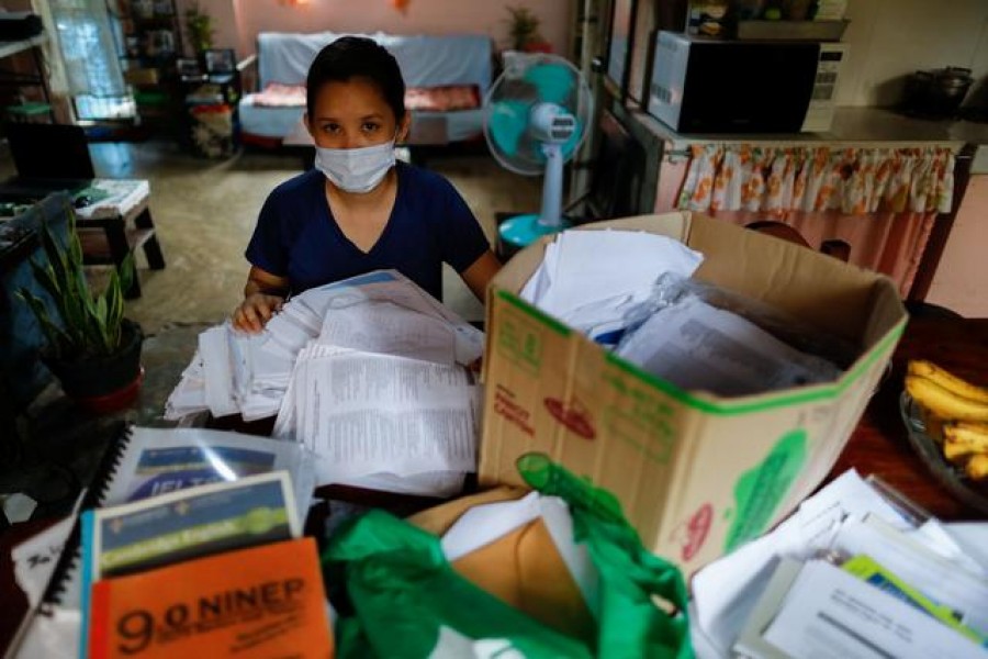 Dean, who asked that her surname not be used, is photographed at her family's home in Caloocan City, Metro Manila, Philippines on September 2, 2020, with boxes of documents she used to apply for a nursing job in the UK — Reuters/Files