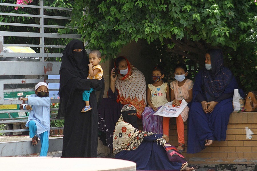 Women with their children rest outside Mugda General Hospital in the capital as they wait for Covid-19 test — File photo