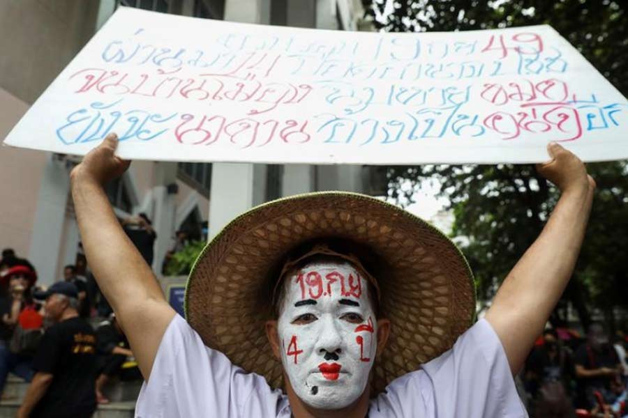 A pro-democracy protester with a painted face holding a placard as he attends a mass rally to call for the ouster of prime minister Prayuth Chan-ocha's government and reforms in the monarchy, in Bangkok, Thailand, on Saturday –Reuters Photo