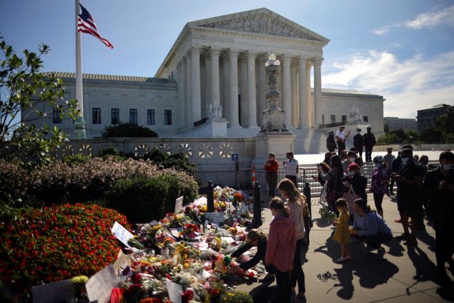 A woman puts flower on a memorial altar as people gather in front of the US Supreme Court following the death of US Supreme Court Justice Ruth Bader Ginsburg, in Washington, US, September 19, 2020 — Reuters