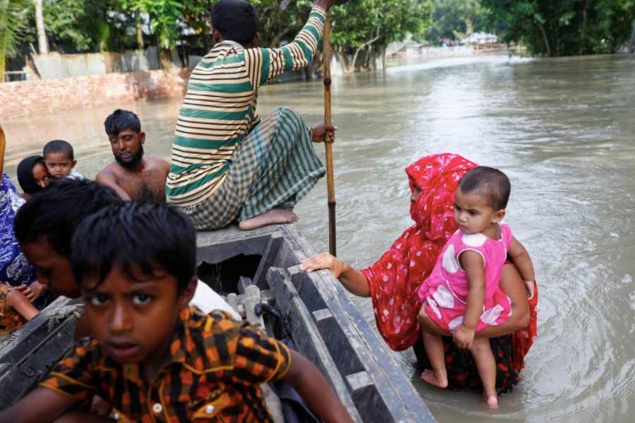 Flood-affected people getting on a boat to cross a stream in Jamalpur district on July 18 this year –Reuters Photo