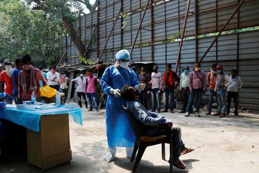 A healthcare worker wearing personal protective equipment (PPE) takes a swab from a migrant laborer for a rapid antigen test at the site of an under construction residential complex amidst a coronavirus disease (Covid-19) outbreak in New Delhi, India on September 19, 2020 — Reuters photo