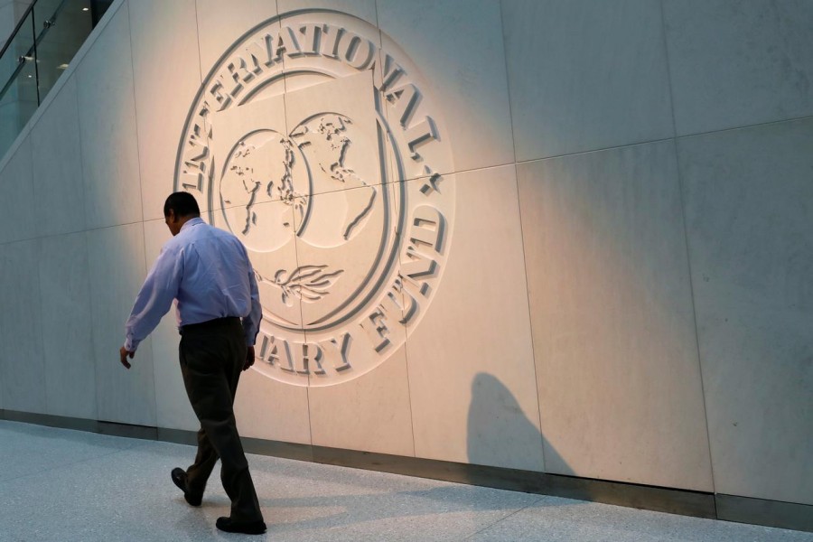A man walks past the International Monetary Fund (IMF) logo at its headquarters in Washington, US on May 10, 2018 — Reuters/Files