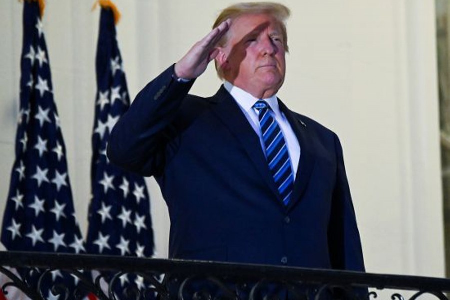 US President Donald Trump salutes as he poses without a face mask on the Truman Balcony of the White House after returning from being hospitalised at Walter Reed Medical Center for coronavirus disease (Covid-19) treatment, in Washington, US on October 5, 2020 — Reuters photo