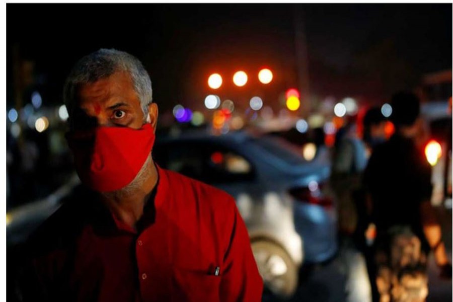 A man wearing a protective face mask waits for a bus, amidst the spread of the coronavirus disease (COVID-19), in the old quarters of Delhi, India, Oct, 6, 2020. REUTERS