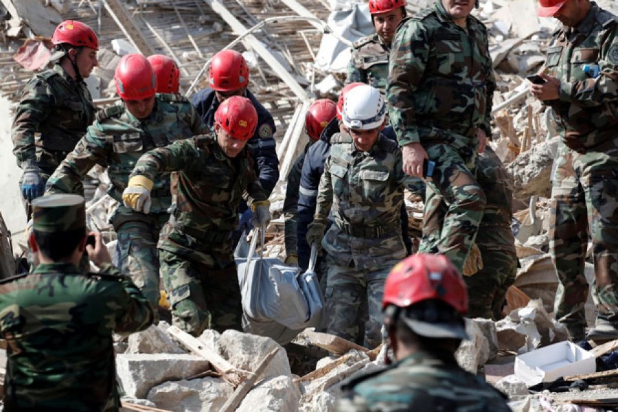 Search and rescue teams carry the body of a victim away from the blast site hit by a rocket during the fighting over the breakaway region of Nagorno-Karabakh in the city of Ganja, Azerbaijan, October 11, 2020 — Reuters