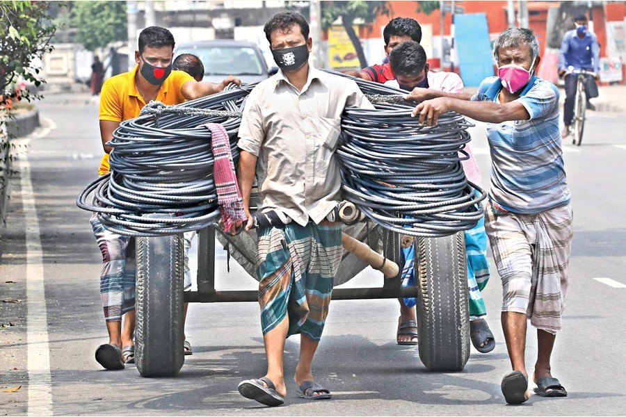 Labourers wearing face masks carry iron rods by a push-cart, as the coronavirus (Covid-19) outbreak continues, at Tejgaon in Dhaka city, June 27, 2020 — FE photo by Shafiqul Alam