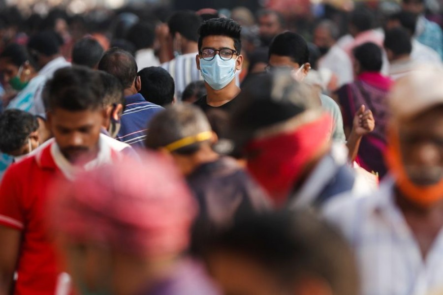 A man wearing a protective mask is seen among people at a crowded market amidst the spread of the coronavirus disease (Covid-19) in Mumbai, India on October 29, 2020 — Reuters photo