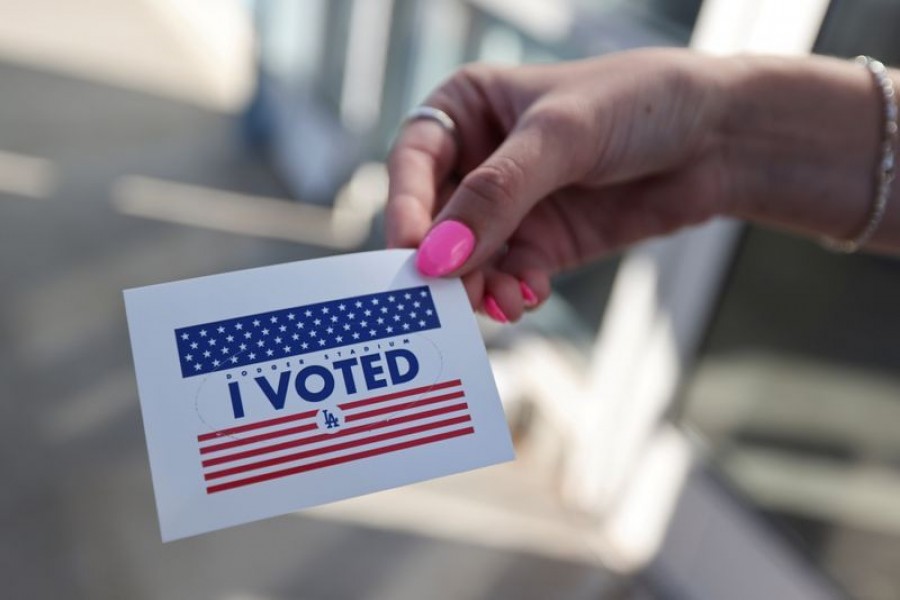 FILE PHOTO: A person holds an "I voted" sticker as people vote in the US presidential election on the first day of expanded California in-person voting, amid the global outbreak of the coronavirus disease (COVID-19), at Dodger Stadium sports venue in Los Angeles, California, US, October 30, 2020. REUTERS/Lucy Nicholson/File Photo