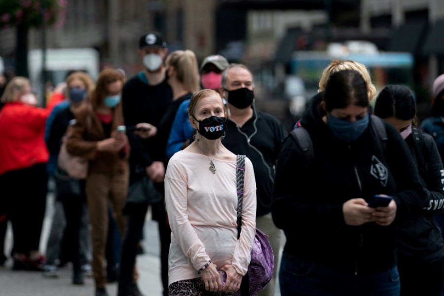 Anxious Americans cast votes with faces masked