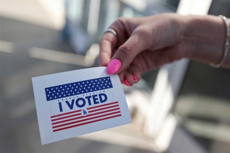 A person holds an "I voted" sticker as people vote in the US presidential election on the first day of expanded California in-person voting, amid the global outbreak of the coronavirus disease (Covid-19), at Dodger Stadium sports venue in Los Angeles, California, US, October 30, 2020 — Reuters