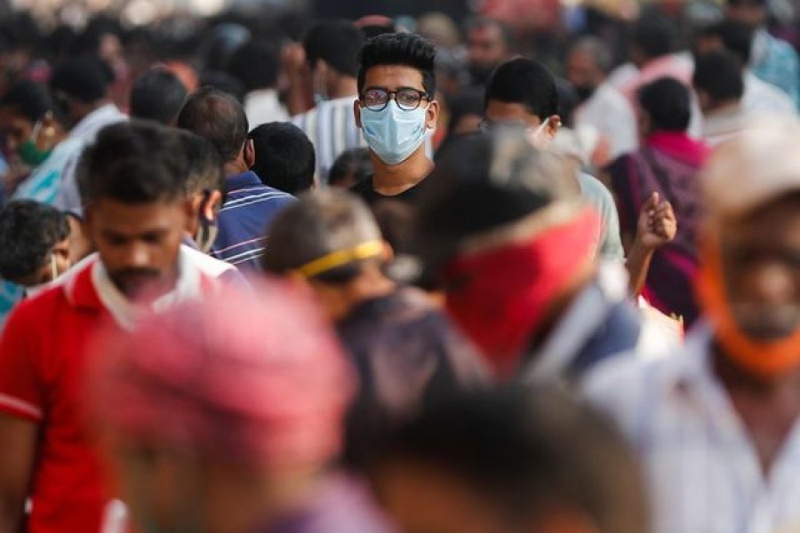 A man wearing a protective mask is seen among people at a crowded market amidst the spread of the coronavirus disease (Covid-19) in Mumbai, India, on October 29, 2020 — Reuters/Files