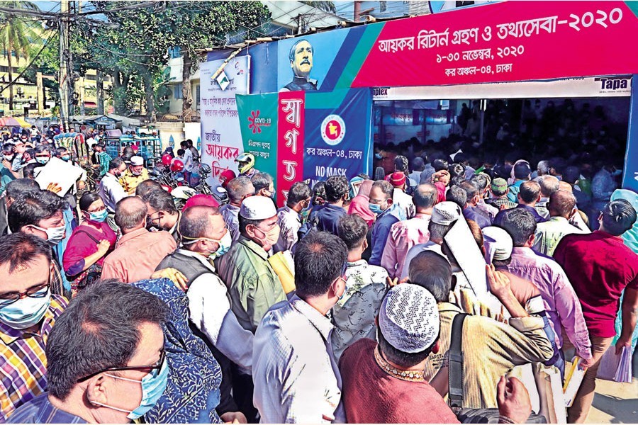 Ignoring social distancing norms, taxpayers wait in long queues to file income tax returns at the Tax Zone-4 at Bijoynagar in the city on Sunday — FE photo