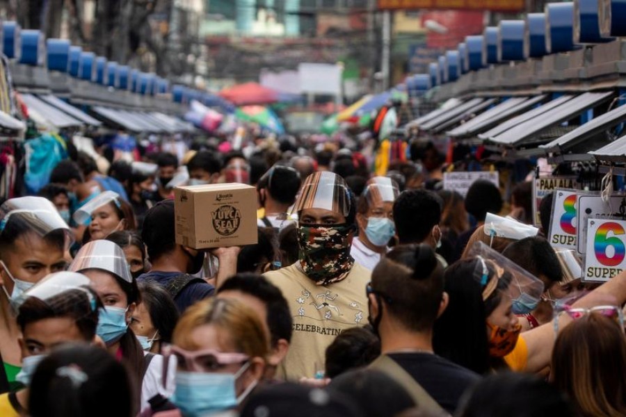 FILE PHOTO: Filipinos wearing masks and face shields for protection against the coronavirus disease (COVID-19) walk along a street market in Manila, Philippines, December 3, 2020. REUTERS/Eloisa Lopez/File Photo