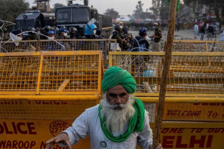 A farmer standing in front of police barricades during a protest against the newly passed farm bills at Singhu border near Delhi on Thursday –Reuters file photo