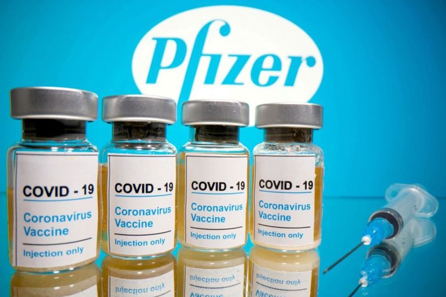 Vials with a sticker reading, "COVID-19 / Coronavirus vaccine / Injection only" and a medical syringe are seen in front of a displayed Pfizer logo in this illustration taken on October 31, 2020 — Reuters/Files