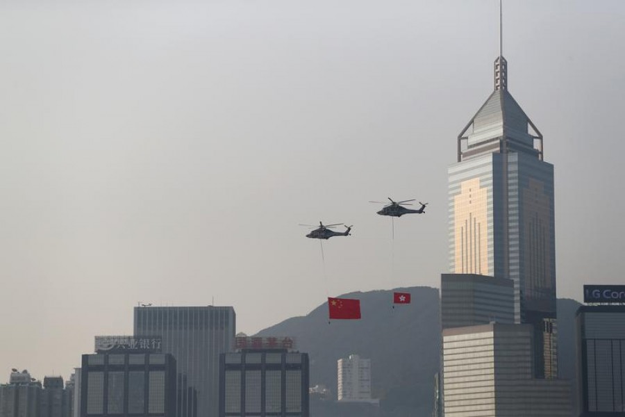 Helicopters carrying China's national flag and Hong Kong's flag fly past the skyline of Victoria Harbour on China's National Day in Hong Kong, China October 1, 2019. REUTERS/Athit Perawongmetha/File Photo