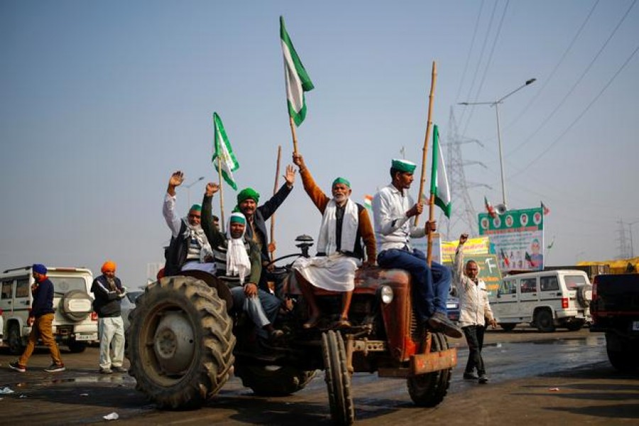 Farmers shout slogans as they sit on a tractor during a protest against farm bills passed by India's parliament, at the Delhi-Uttar Pradesh border in Ghaziabad, India, December 16, 2020 — Reuters