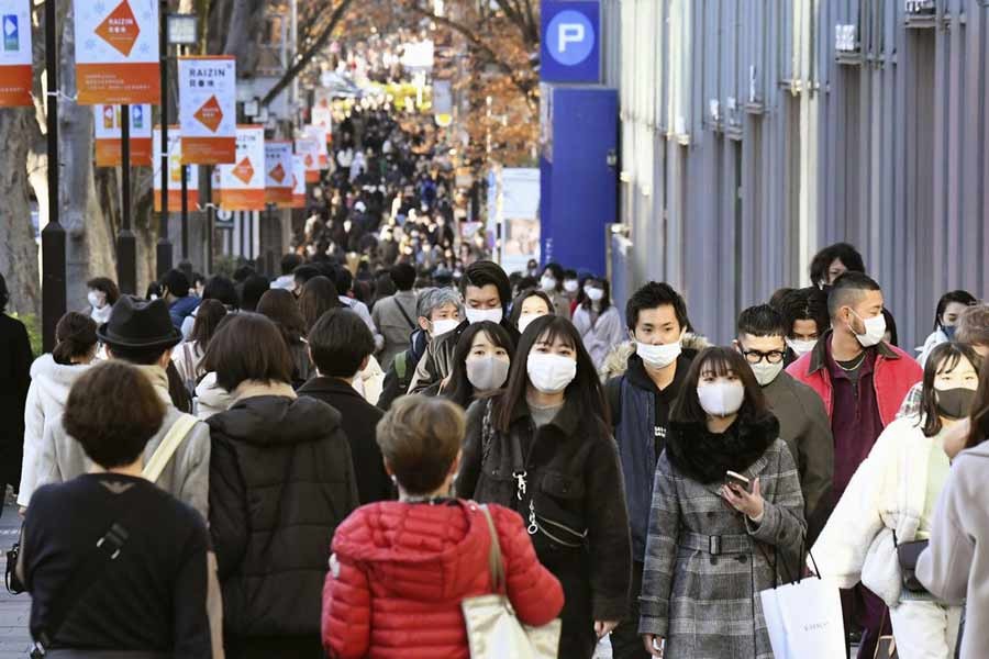 People wearing face masks to help curb the spread of the coronavirus walking on Aoyama shopping street in Tokyo on Sunday –AP Photo