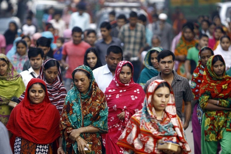 In this Feb 13, 2014 file photo, Bangladeshi garment workers arrive for work early morning in Dhaka, Bangladesh — AP Photo