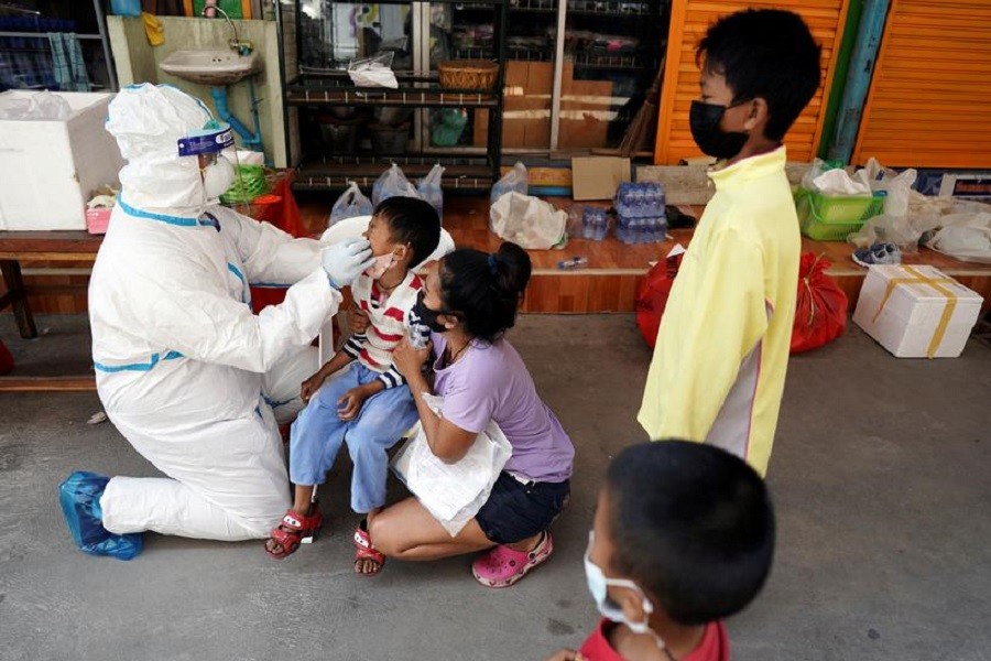 A healthcare worker takes a nasal swab sample of a child for a Covid-19 test at a migrant community, amid the coronavirus disease (Covid-19) outbreak, in Samut Sakhon province, in Thailand, December 20, 2020 — Reuters/Files
