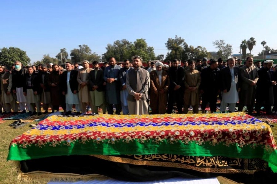 Afghan men pray near the coffin of journalist Malalai Maiwand, who was shot and killed by unknown gunmen in Jalalabad, Afghanistan, December 10, 2020 [Parwiz/Reuters]