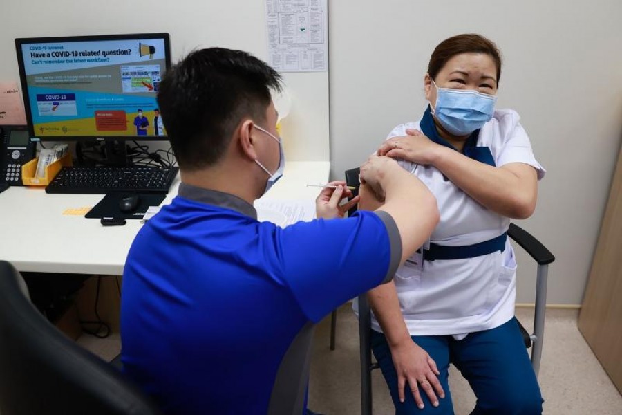 Healthcare worker Sarah Lim receives her coronavirus disease (COVID-19) vaccine at the National Centre for Infectious Diseases (NCID) in Singapore December 30, 2020. Lee Jia Wen/Ministry of Communications and Information/Handout via REUTERS