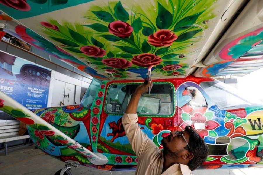 A man paints Pakistani truck art on a two-seater Cessna aircraft at general aviation area at Jinnah International Airport in Karachi, Pakistan, December 30, 2020 — Reuters/Files