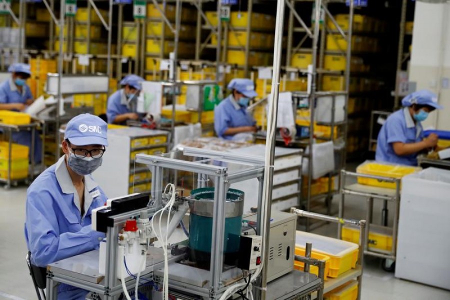 Employees wearing face masks work at a factory of the component maker SMC during a government-organized tour of its facility following the outbreak of the coronavirus disease (COVID-19), in Beijing, China May 13, 2020. REUTERS/Thomas Peter