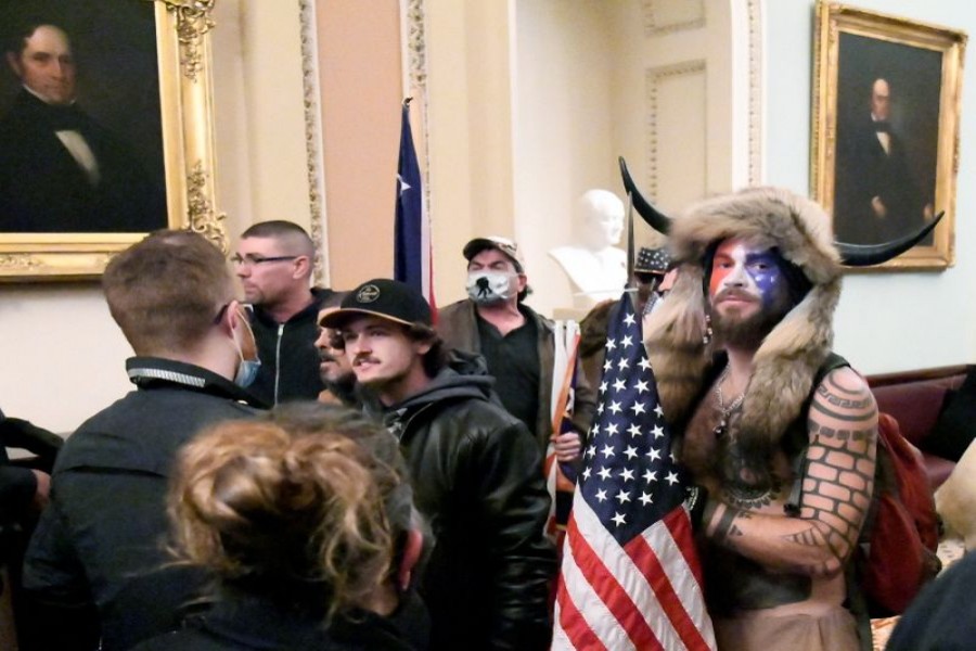 Jacob Anthony Chansley, also known as Jake Angeli, of Arizona, stands with other supporters of U.S. President Donald Trump as they demonstrate on the second floor of the U.S. Capitol near the entrance to the Senate after breaching security defenses, in Washington, U.S., January 6, 2021. REUTERS/Mike Theiler/File Photo