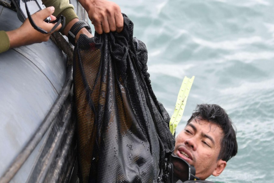 Indonesia Navy diver recovers what are believed to be remains from Sriwijaya Air Flight SJ182, which crashed into the sea off the coast of Jakarta, Indonesia, January 10, 2021 in this photo taken by Antara Foto/M Risyal Hidayat via REUTERS