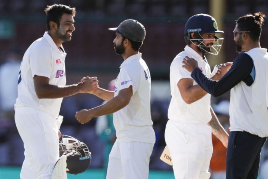 India's Ravichandran Ashwin, left, is congratulated by his captain Ajinkya Rahane as Hanuma Vihari is congratulated by teammate Mohammed Siraj, right, following play on the final day of the third cricket test between India and Australia at the Sydney Cricket Ground, Sydney, Australia, Monday, Jan. 11, 2021. (AP Photo/Rick Rycroft)